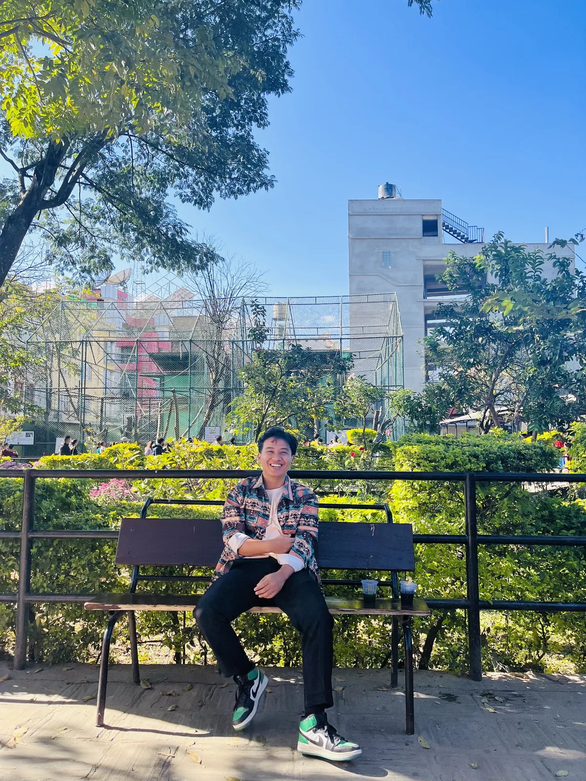 Aashish Thakuri smiling on a park bench